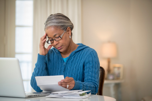 487701729-senior-african-american-woman-paying-bills-gettyimages
